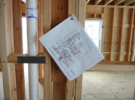 Kitchen design schematic hanging on wall for construction contractor